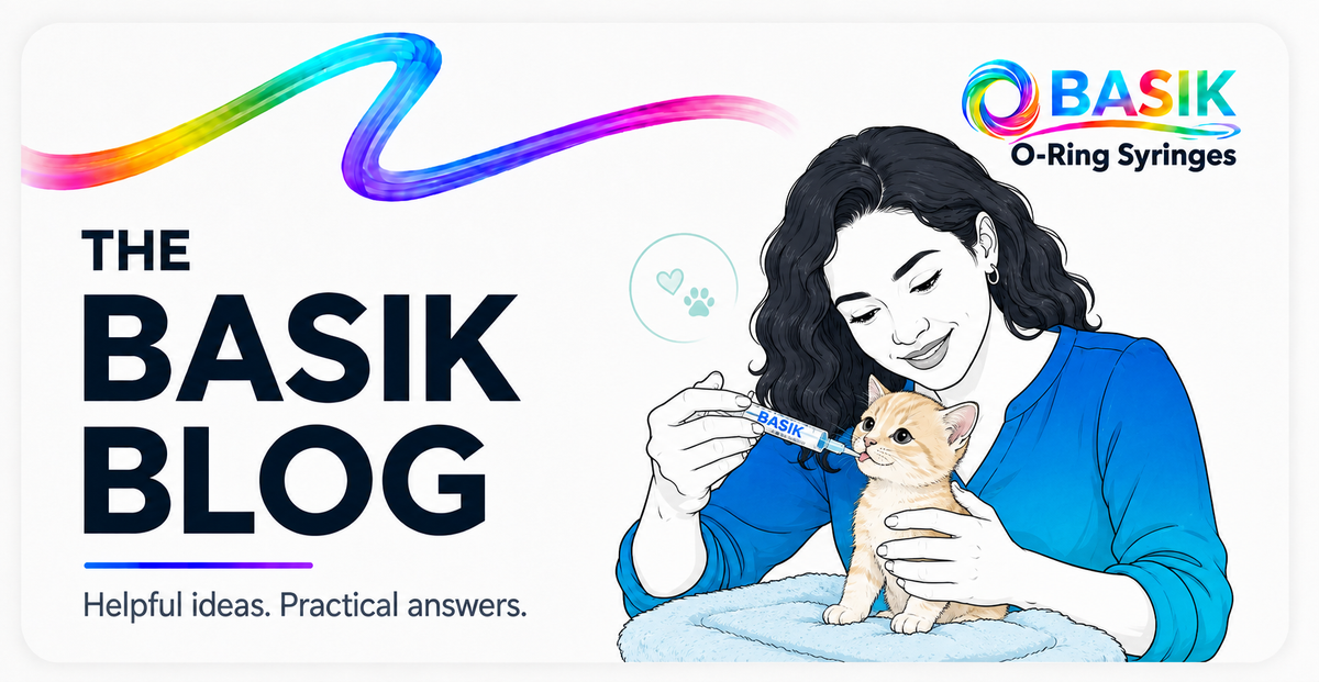 woman hand feeding by mouth a small cat with a basik syringe